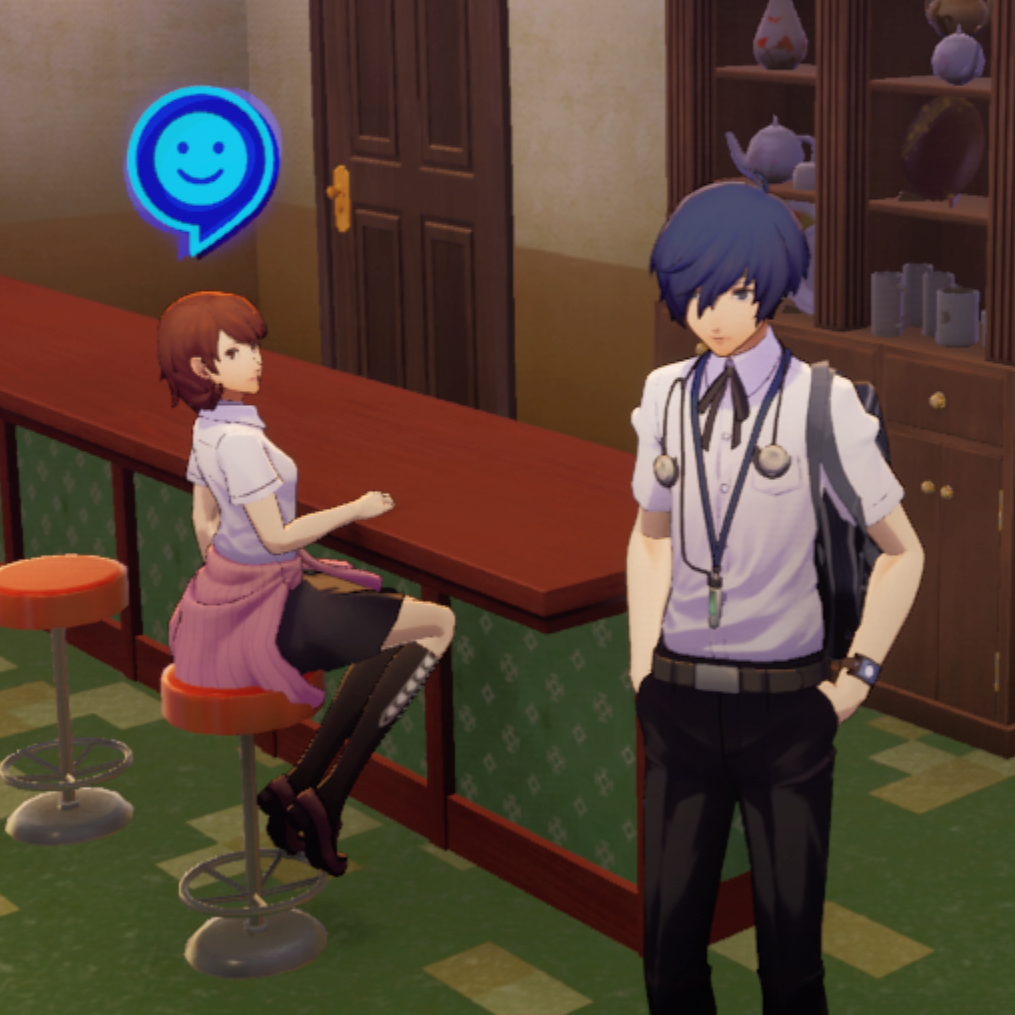 Yukari looking fashionable, sitting tall on a stool to the left of Makoto Yuki with a blue happy face icon above her, and Makoto standing to her right.
